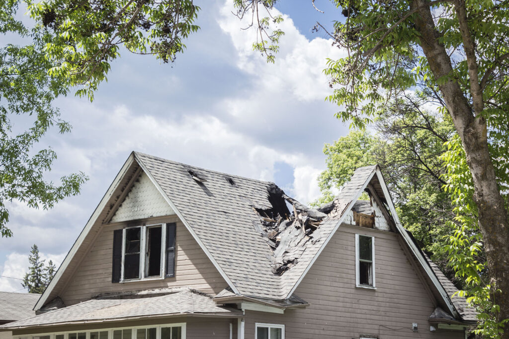 horizontal close up image of a roof of a house that has burned a
