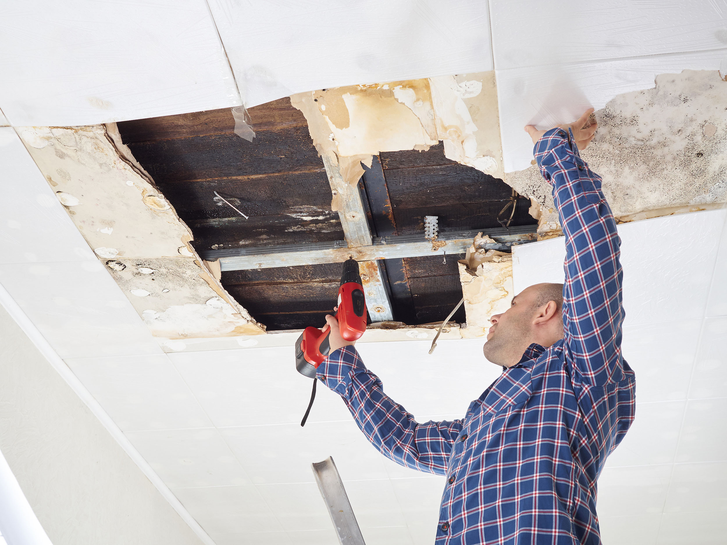 Man repairing collapsed ceiling